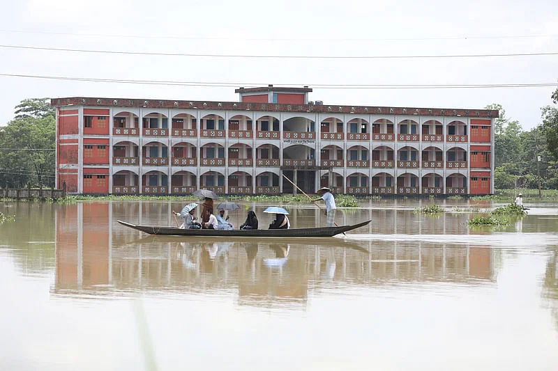 People using boat to go from one place to another as roads are submerged due to the flood in Beanibazar, Sylhet